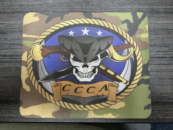 A mouse pad with the company CCCA logo with a skull